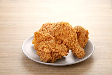 crispy fried chicken in grey dish on wood table