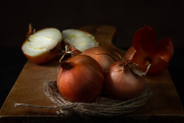 Onions on a wooden surface. Healthy vegetables. Whole and halves onions lie next to each other