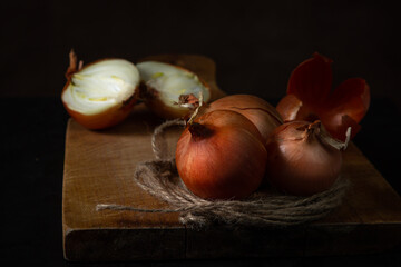 Onions on a wooden surface. Healthy vegetables. Whole and halves onions lie next to each other