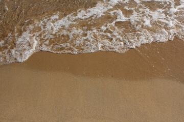 Fototapeta na wymiar brown Sand beach and Wave foam.