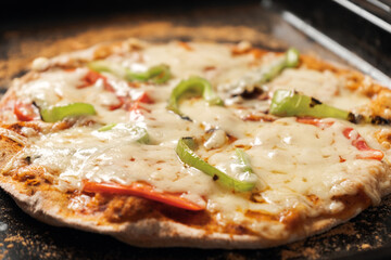 Vegetarian pizza on a whole-wheat flour dough on a hot baking sheet