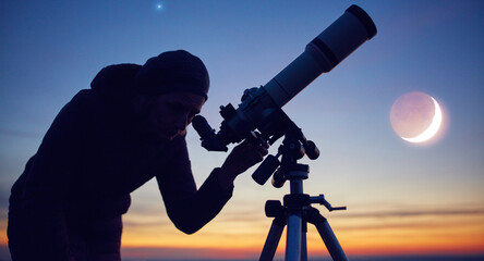 Woman looking at night sky with amateur astronomical telescope.