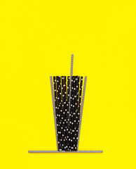 imitation paper cup made of black paper tubes on a yellow background