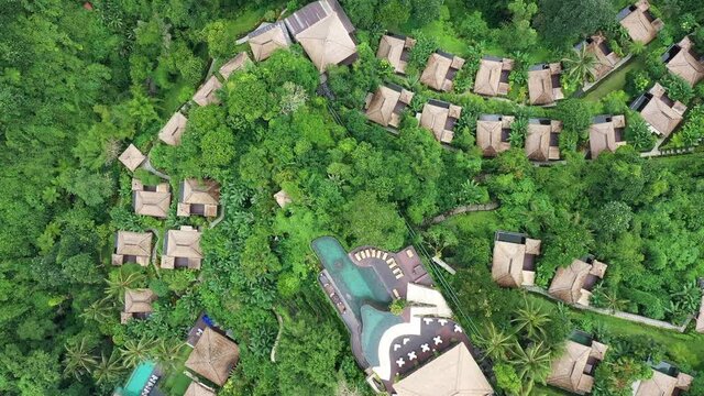Aerial top down view ofa resort hotel which lies in a tropical valley in Ubud, Bali. Shot with a slight downward and rotation motion