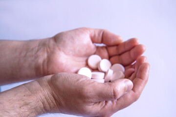 Beautiful men's hands with pills on a light background. Side view