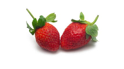 Close up view of two fresh red strawberries with leaves on isolated white background.