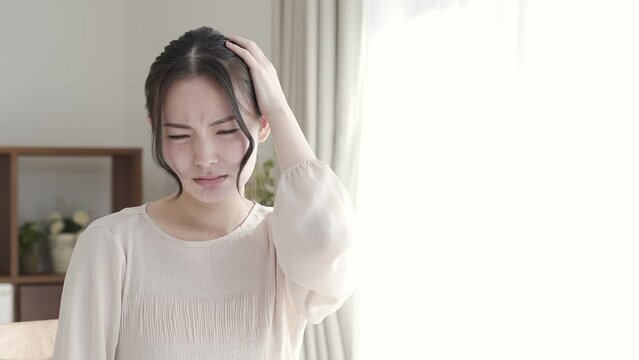 リビングで悩む若い女性