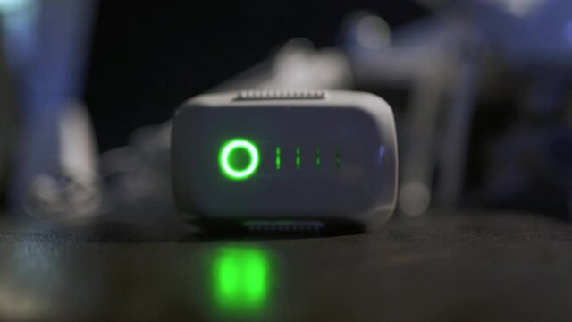 Исходный текст
The battery from the drone is being charged in close-up and the charge indicator is shown in neon green stripes across it.
