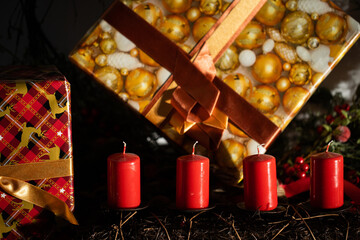 Four red candles on the phone packages with presents prepared for family and friends as a Christmas gift.