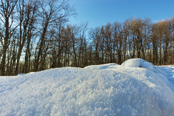 Obraz premium A snowdrift covered with ice crystals. Winter landscape on a sunny day