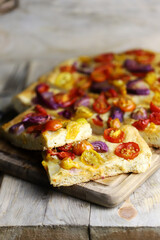 Fresh homemade focaccia with blue onions and cherry tomatoes.