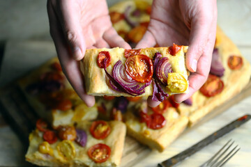Fresh homemade focaccia with blue onions and cherry tomatoes.