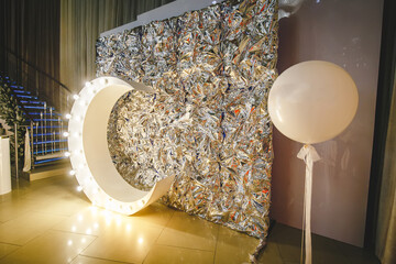 Photo zone in white silver style foil with large, voluminous paper figure of moon with lamps and...