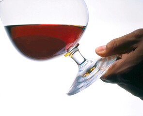 Hand holding wine glass on white background