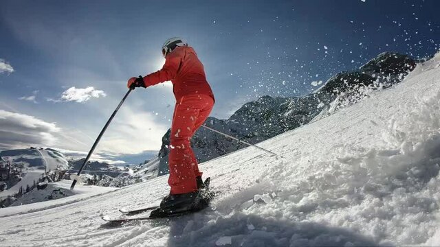 Pretty woman skiing. Young girl rides along the freshly groomed slope. 
Young girl spending an active vacation in the Austrian Alps. Stabilized footage. Slow motion. 