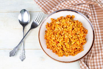 Traditional turkish bulgur pilaf with tomato sause in plate (Turkish name; meyhane pilavi)
