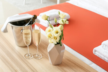 Glasses of champagne and ice bucket on table in honeymoon room