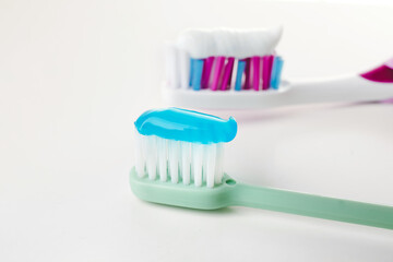 Toothbrushes with paste on white background