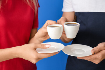 Young couple with hot coffee on color background, closeup