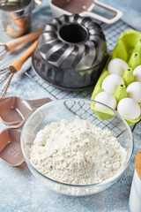 Baking ingredients and utensils, flour, eggs, baking dish on light background