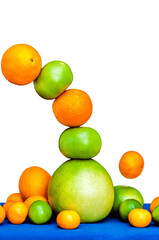 Falling tower of citruses, oranges, pummelo, limes, tangerines and grapefruits isolated on white background