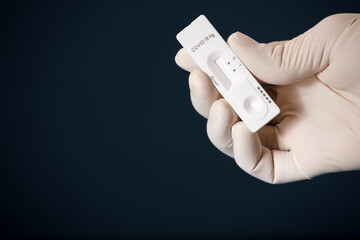 Doctor holding a test kit for viral disease tests with the COVID-19 SARS-CoV-2 laboratory card kit...