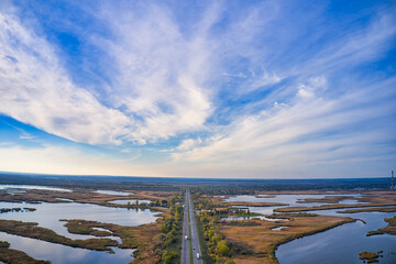 The road passes through the Samarskie Plavni picturesque Ukraine in the evening light