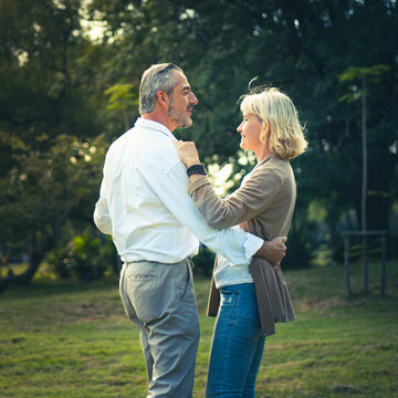 Happily Elderly Dancing Together At Outdoor In The Park With Warming Sunlight Atmosphere, Worry Free For Retirement Senior People, Lovely Older Lifestyle Healthy And Happiness. Couple Relaxing Outdoor