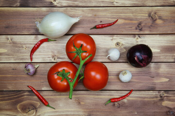 Top down view on raw uncooked isolated white and red onions, tomatoes vine and chillies. Brown natural rustic wooden background. Healthy ingredients for spicy tomato salad. © Ralf