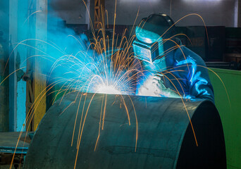 Industrial welding process is being done by a welder for metal fabrications 