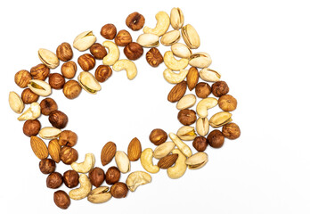 Frame of hazelnuts, almonds, cashews and pistachios on a white background. Place for text