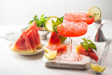 Watermelon frozen cocktail margarita with fresh watermelon, lime and mint on white background
