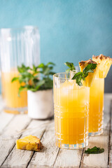 Fresh pineapple cocktail in the glass with ice and mint, summer drink