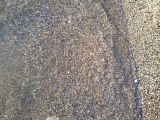 shoreline with small pebbles and water close-up. High quality photo