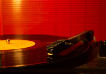 A closeup of an old eighties retro vintage record LP player turntable turning with orange...