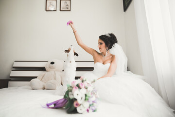 Obraz na płótnie Canvas Luxury bride in white dress posing while preparing for the wedding ceremony