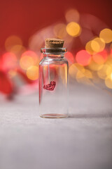 Glass jar and red heart on red background. Concept of love in Valentine's Day.