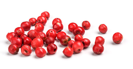 Red or Pink peppercorn scattered on board, closeup photo isolated with white background