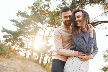 Fototapeta premium Embraces each other. Cheerful lovely young couple having a rest outdoors together