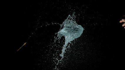 A high-speed image of a thrown dart hitting a Water Balloon, and popping it.