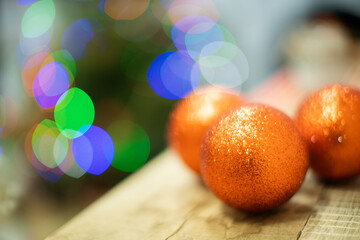 Gold-orange Christmas balls lie on a wooden board. Festive mood. Christmas time. Shiny Christmas...