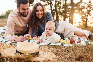 Haves picnic. Happy family of mother, family and little baby rests outdoors. Beautiful sunny autumn...