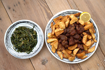 grilled pork with french fries and salad on a wooden table