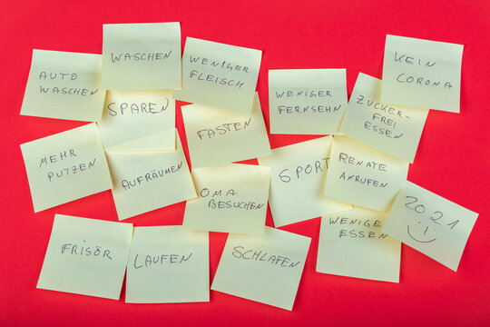 Gute Vors&auml;tze f&uuml;r das neue Jahr 2021, geschrieben auf post-its auf rotem Hintergrund