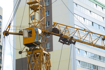 Tower crane on a construction site at high-rise building, closeup view. Construction of residential...