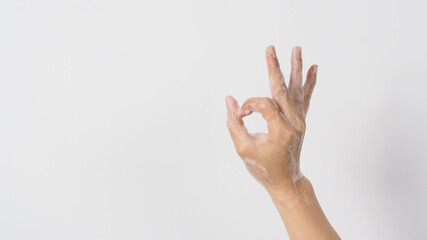 Hand doing ok hand sign gesture and wash foaming hand soap.shoot on white background.