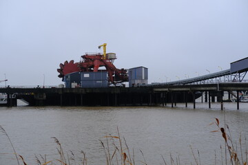Fototapeta na wymiar The harbour installation on the Loire river for the coal delivery to the coal-fire plant. (city of Cordemais - 21th december 2020)