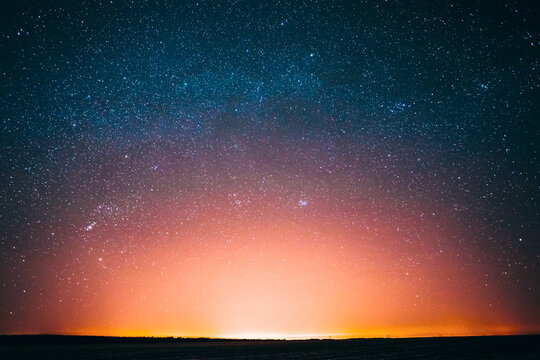 Amazing Beautiful Night Sky Glowing Stars Background Backdrop With Colorful Sky Gradient. Sunset Sunrise Light And Colourful Night Starry Sky In Blue Yellow Pink Orange Colors. Dark Ground Silhouette