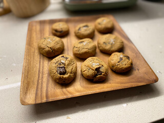 Paleo Chocolate Chip Cookies Made with Coconut and Almond Flour in Wooden Plate. Organic Food with Melted Chocolate.