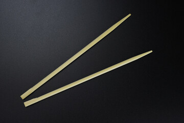 Wooden chopsticks, sushi sticks on a black background